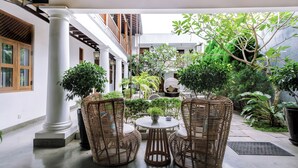 A courtyard with wicker furniture, a round table, and potted plants. - Yara Galle Fort (Galle)