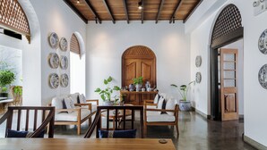 A dining area with wooden furniture, a central wooden table, and a decorative wooden door. - Yara Galle Fort (Galle)