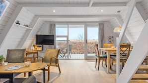Une chambre moderne de style loft, dotée d’une grande télévision, de meubles en bois et d’un balcon avec vue.