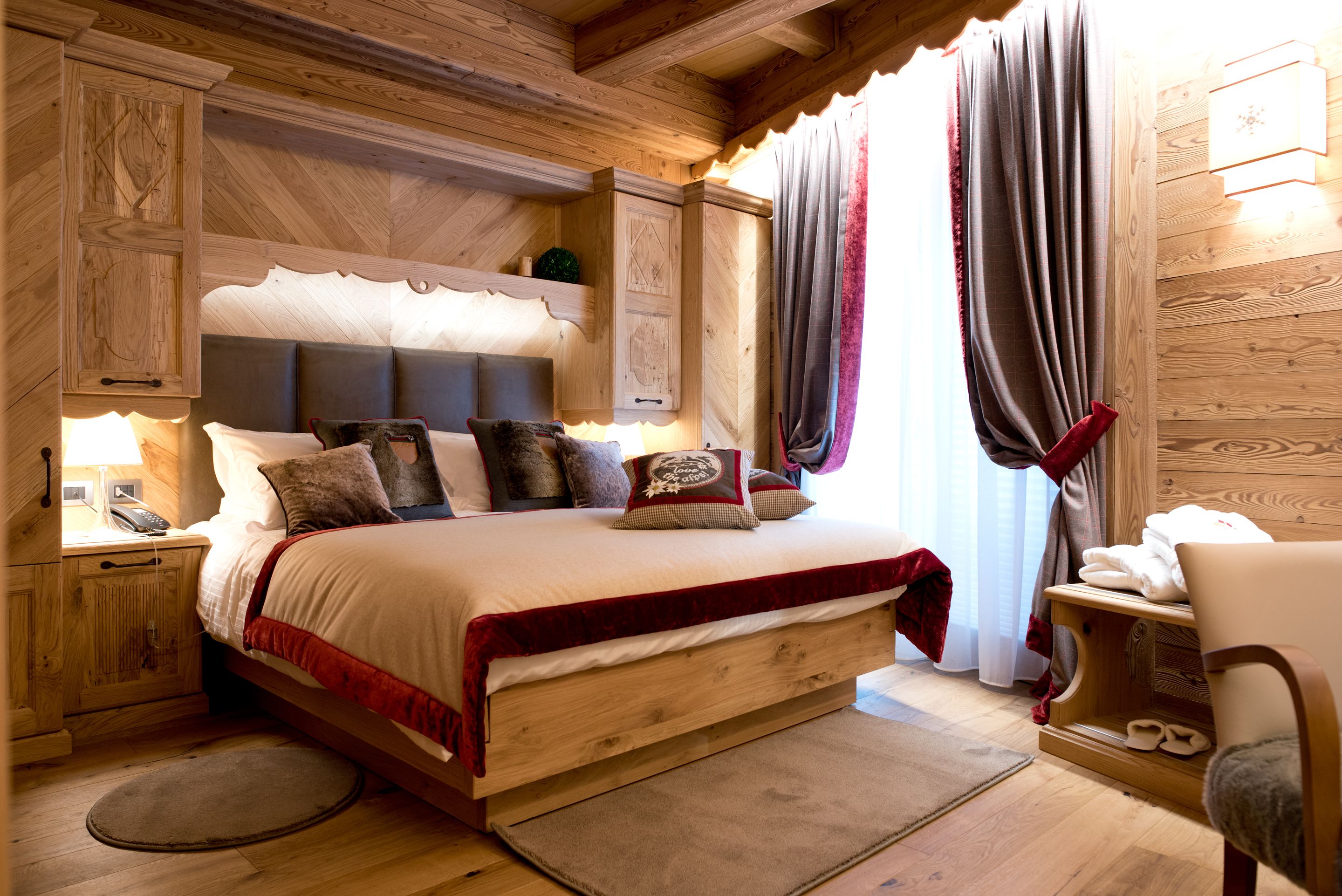 Camera da letto in legno con un letto, comodini e una sedia.