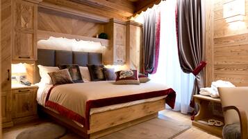 Camera da letto in legno con un letto, comodini e una sedia.
