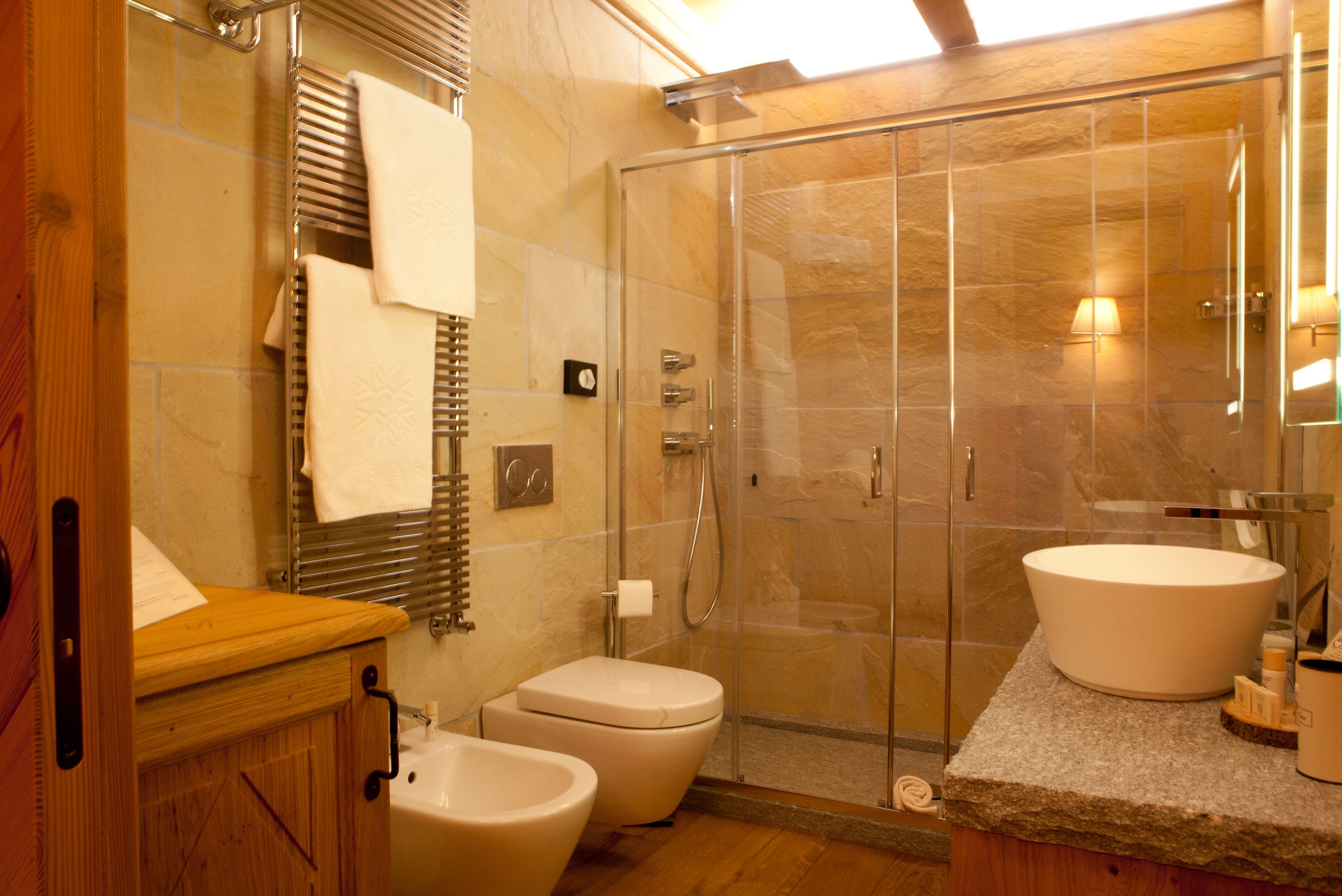 A modern bathroom with a glass shower enclosure, a freestanding bathtub, and a large sink.