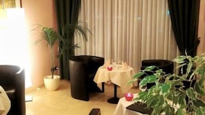 A dining area with a table set for two, a potted plant, and a lamp. - Executive Hotel Udine (Udine)