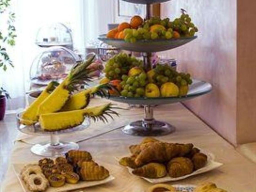 A buffet with a variety of fruits and pastries.