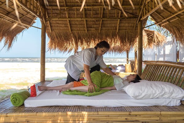 A massage therapy session on a bamboo mat with a thatched roof, overlooking a beach. - Triple Tree Beach Resort (Cha-am)