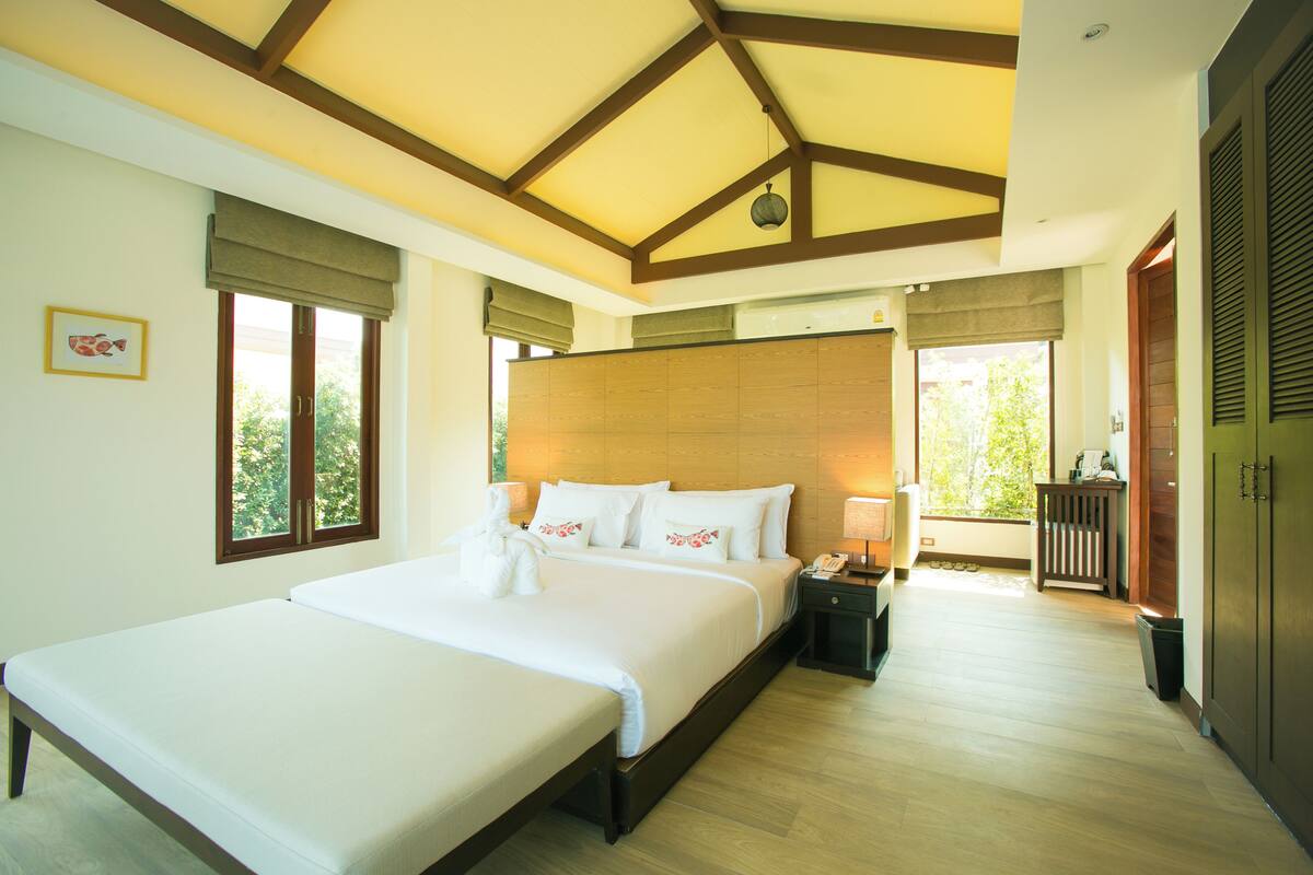 Habitación de hotel con una cama grande, mesitas de noche, un escritorio y vistas al exterior.