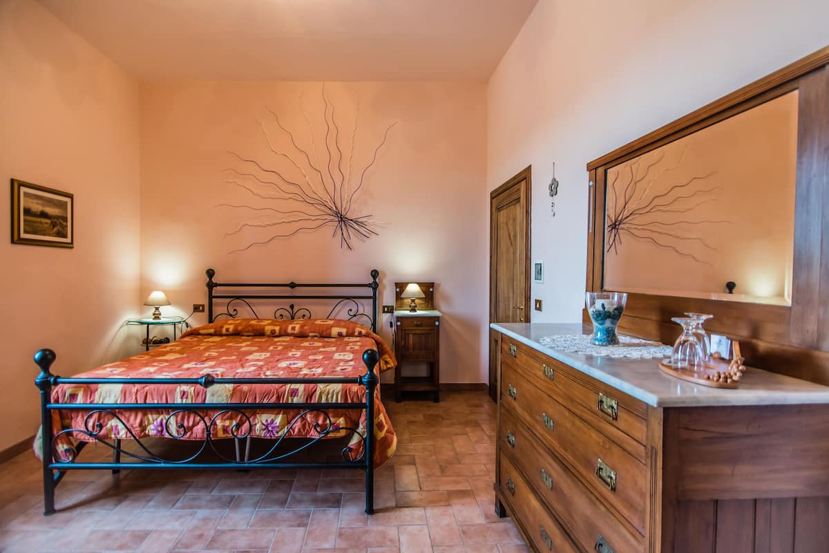 Une chambre à coucher comprenant un lit, une commode, une table de chevet et des éléments de décoration murale.