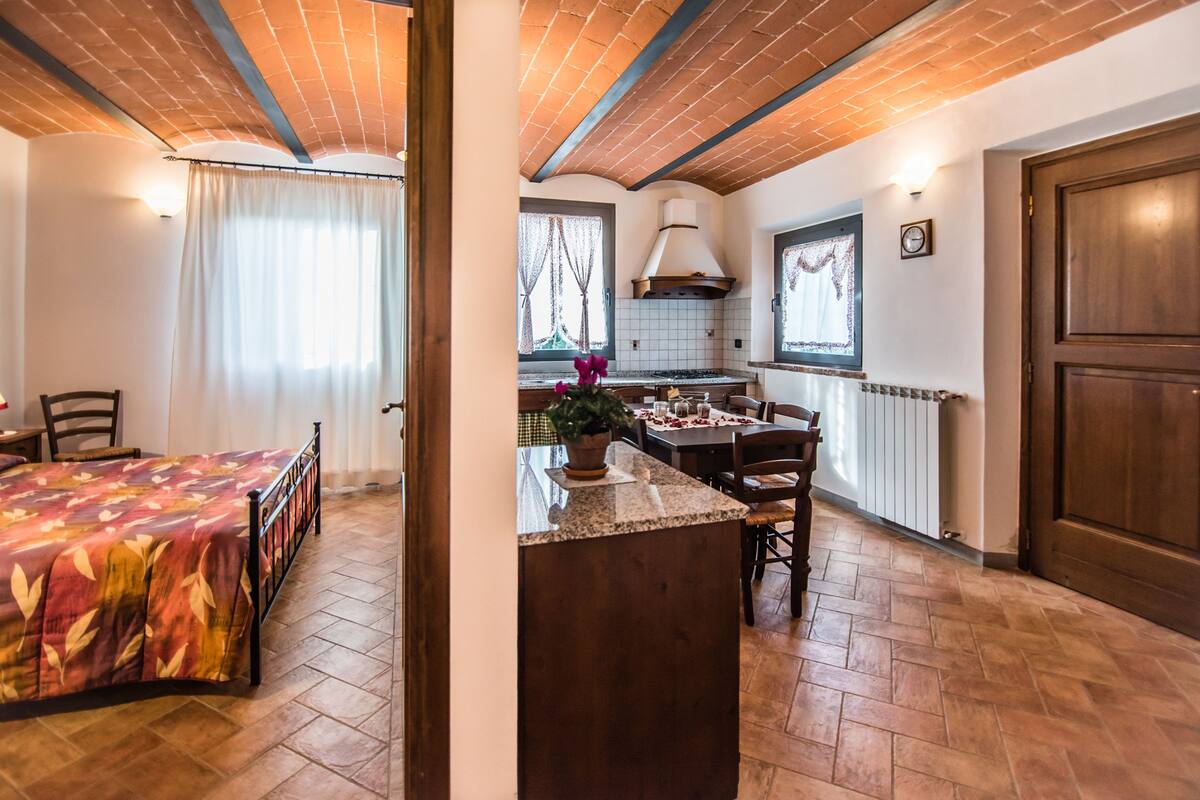 Une pièce comprenant un lit, une table à manger et un coin cuisine.
