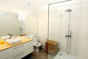 A modern bathroom with a glass shower enclosure, a wooden vanity, and a toilet. - Apartments 27 Mae de Deus by Green Vacations (Ponta Delgada)