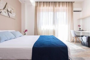 Una habitación de hotel con una cama, un escritorio y una silla.
