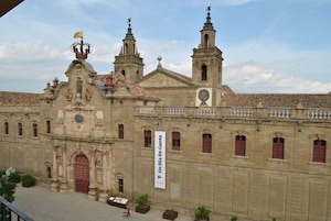 Un edificio histórico con una entrada destacada, una torre del reloj y un cartel que dice "Un Dia De Monte".