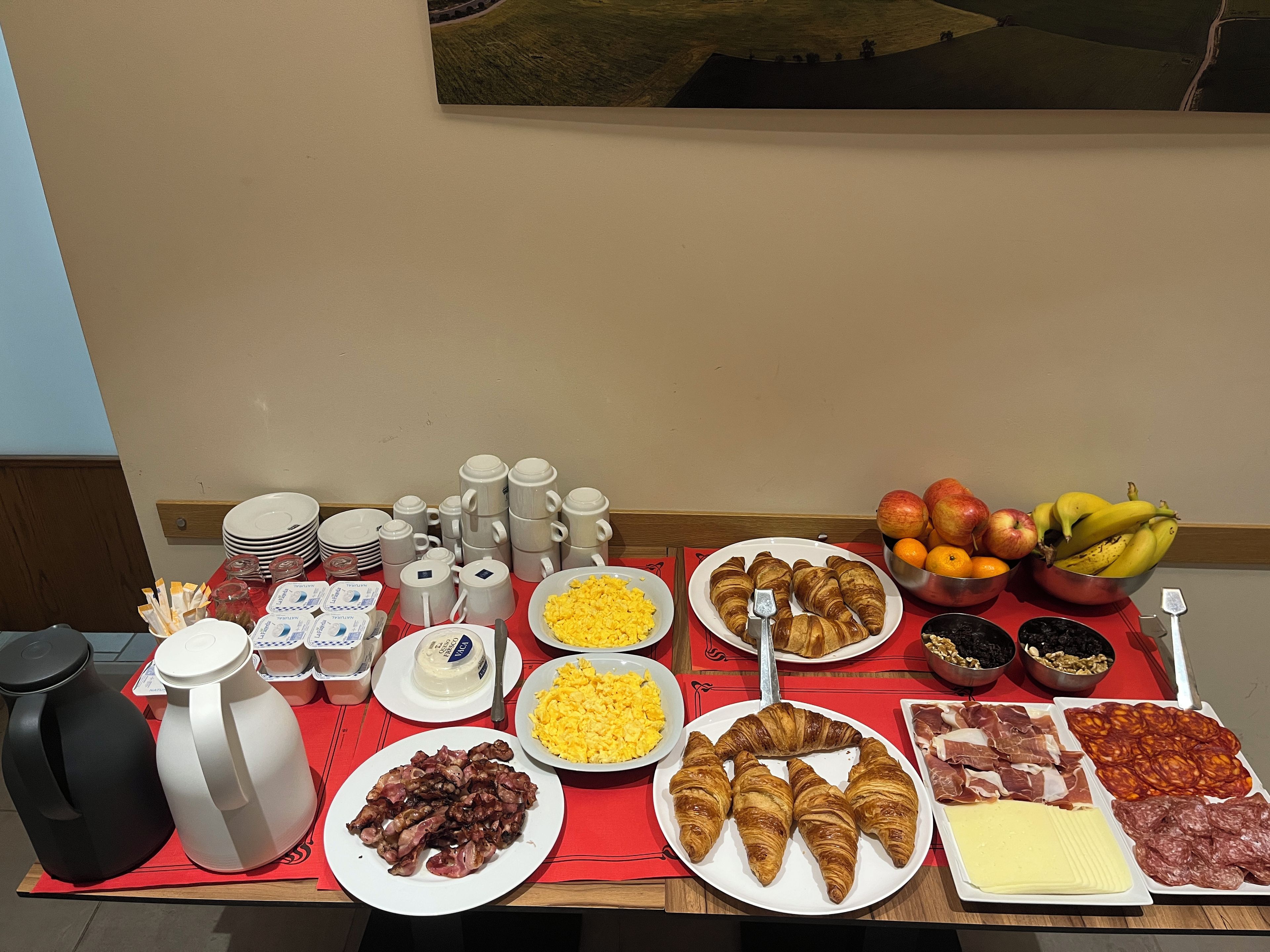 Un bufé de desayuno con diversos alimentos y vajilla.