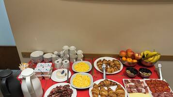 Un bufé de desayuno con diversos alimentos y vajilla.