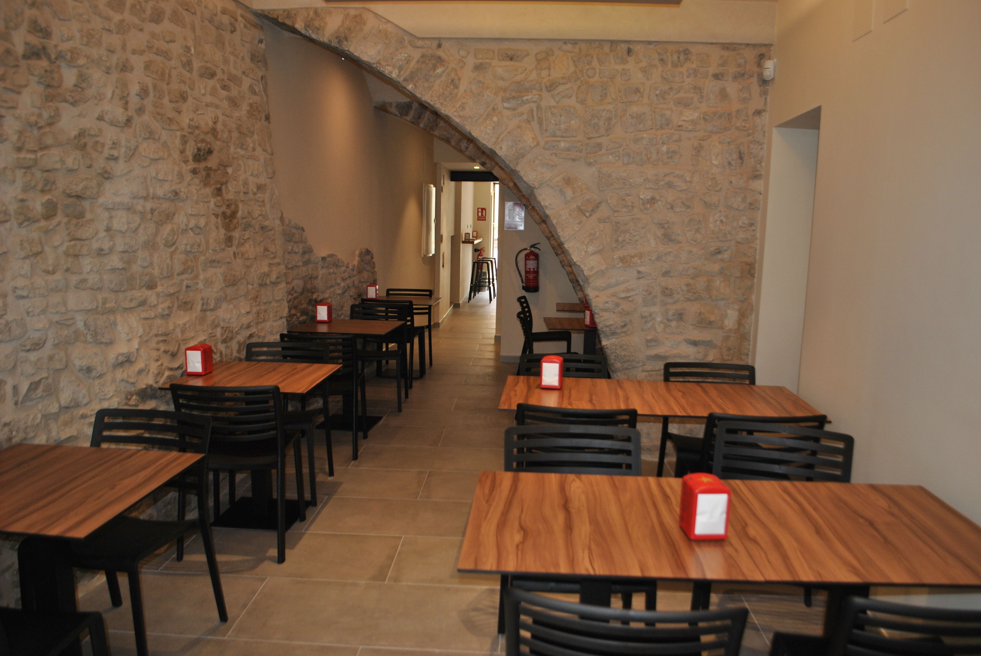 Um restaurante com paredes de pedra e mesas e cadeiras de madeira.