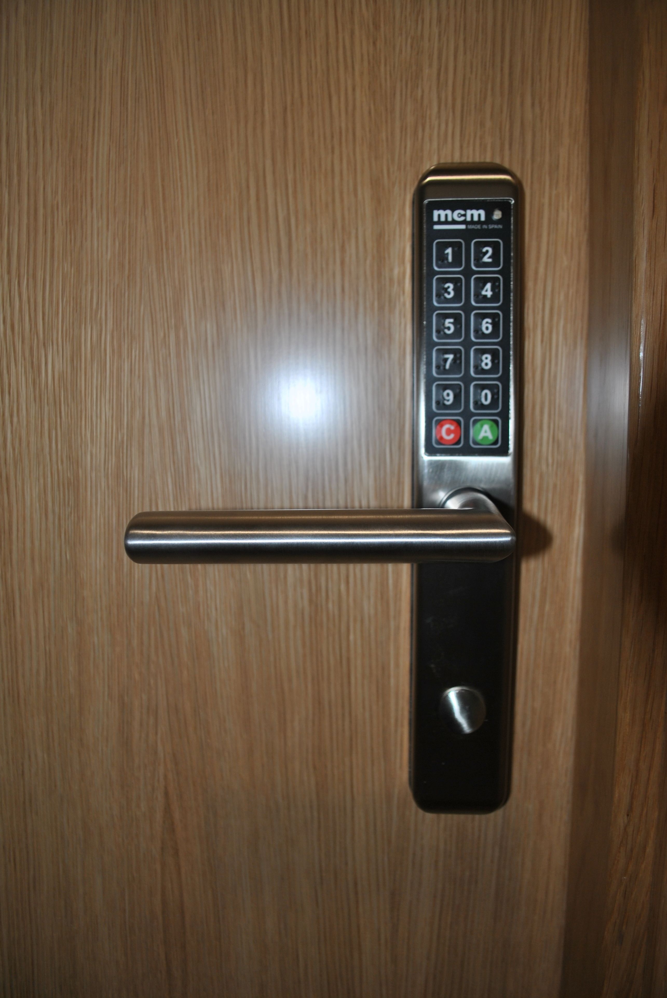 A door with a keypad lock and a metal handle.