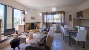 A modern living room with a sofa, chairs, a dining table, and a TV. - Ioanna's Home (Malevizi)