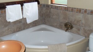 A bathroom with a bathtub, a sink, and a toilet. There are two towels hanging on a rack.