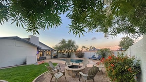 A backyard with a fire pit, outdoor seating, a swimming pool, and a well-maintained lawn. - Spacious Yard, Pool, Pet & Kid Friendly, Close to Everything! (Mesa)