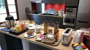 Een moderne keuken met een ontbijtbuffet, inclusief diverse etenswaren, een koffiezetapparaat en een broodrooster.
