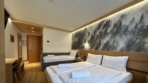 A hotel room with two beds, a desk, and a wall mural of a forest. - Hotel Gran Zebrù (Pejo)