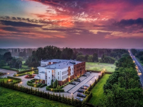 A modern building with a parking lot and landscaped areas.. Mercure Wiazowna Brant