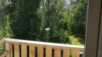 A wooden deck with a view of a green landscape and trees.