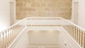 Een trap met witte balustrades en een achtergrond van een stenen muur.