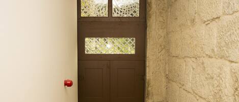 A narrow stairway leading to a door with a frosted glass window.