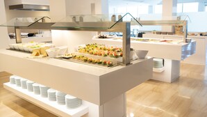 Un buffet avec plusieurs points de service, des présentoirs en verre et des assiettes disposées avec soin.