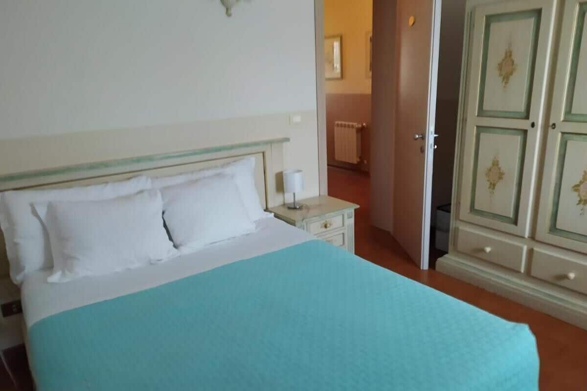 Une chambre à coucher avec un lit, une table de chevet et une armoire.