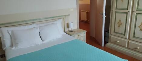 A bedroom with a bed, bedside table, and wardrobe.
