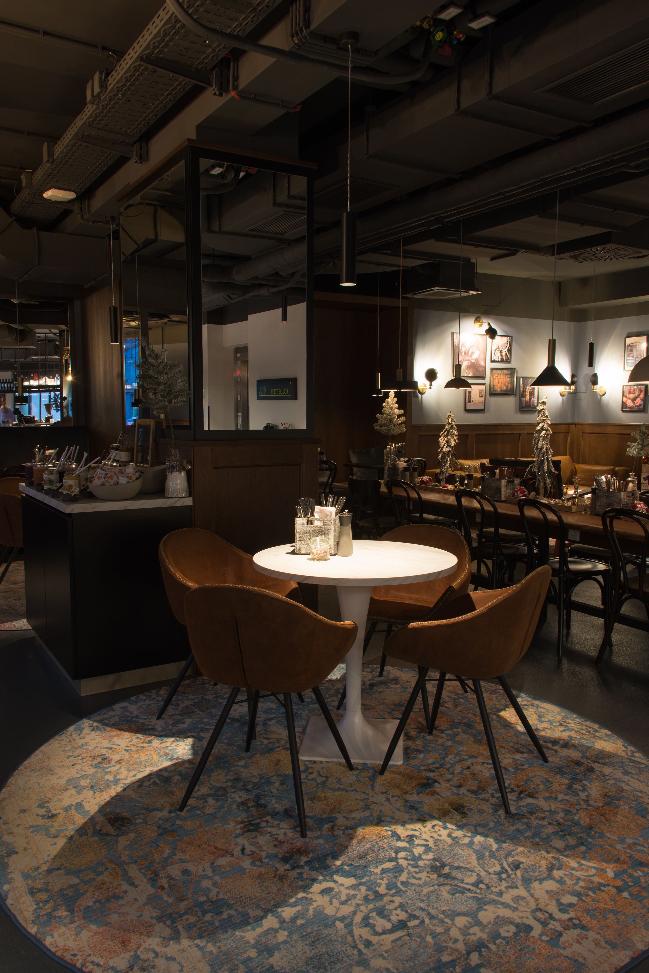 Un restaurant avec une table ronde, des chaises marron et un tapis à motifs.