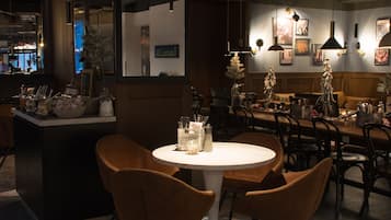 Un restaurant avec une table ronde, des chaises marron et un tapis à motifs.