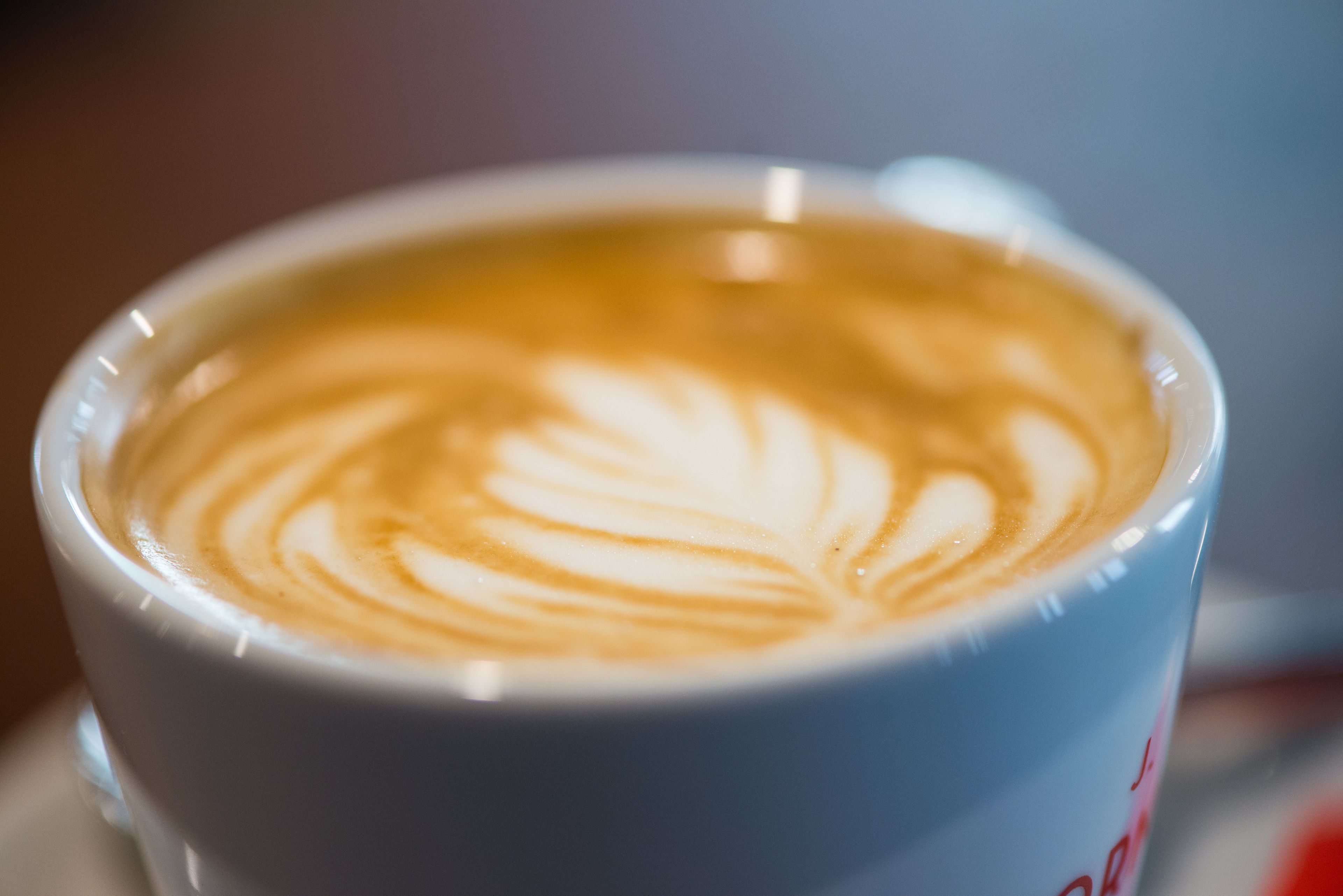 A close-up of a cup of coffee with latte art.
