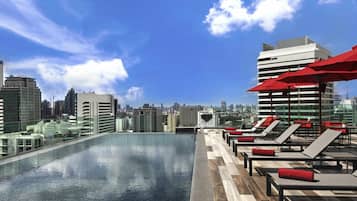 Una piscina al aire libre, sombrillas, tumbonas