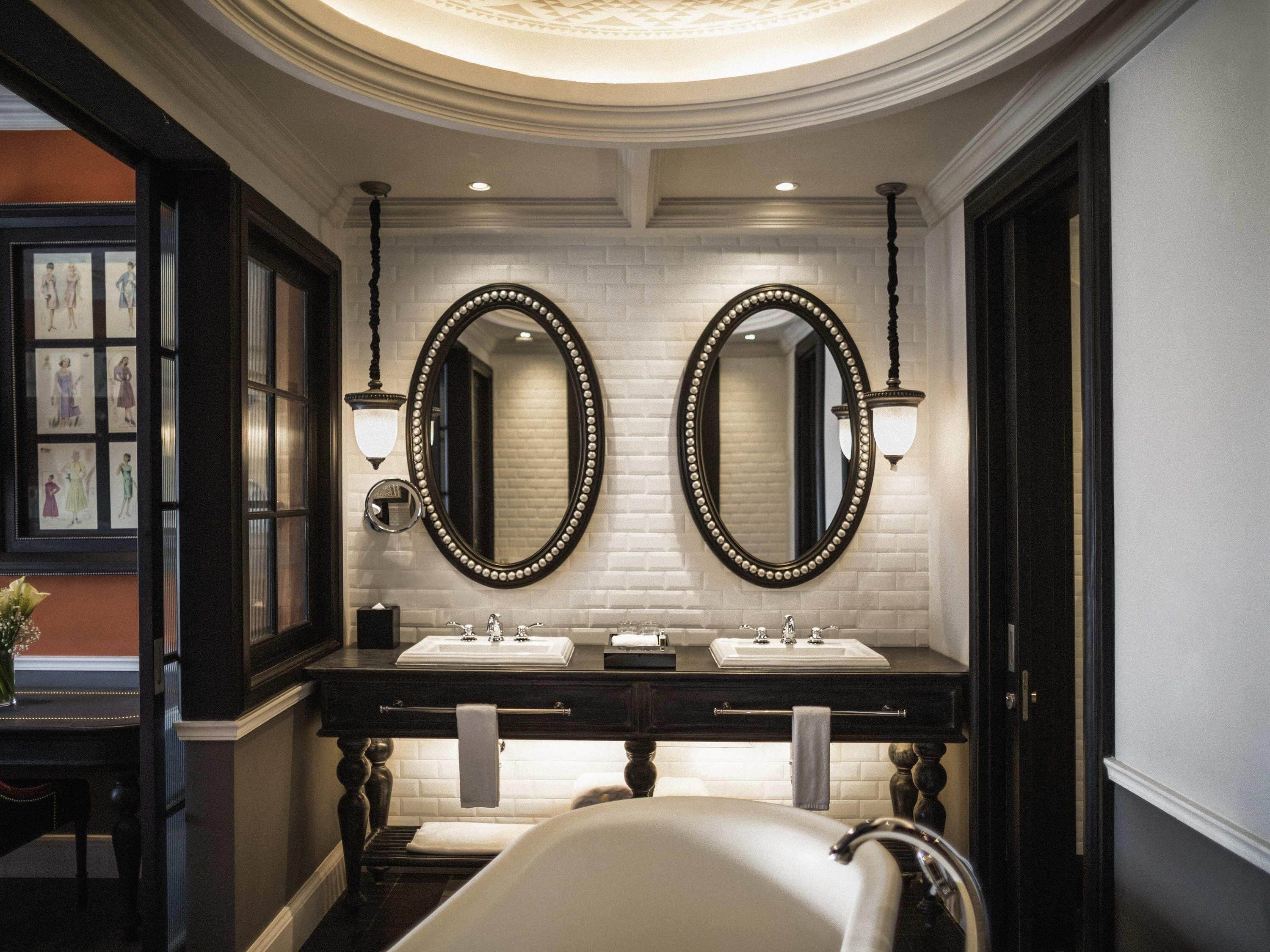 A bathroom with two sinks, a large mirror, and a bathtub.
