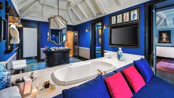 Une salle de bain luxueuse avec une grande baignoire, un meuble-lavabo avec un miroir et une décoration aux couleurs bleue et rouge.
