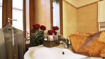 A bathroom with a sink, a wooden door, and a window.