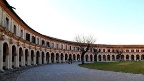 Um pátio com um edifício curvo, com passarelas em arco e um espaço aberto central.