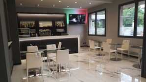 Un área de bar moderna con un arreglo de asientos, una pantalla de televisión y una exhibición de botellas de licor.