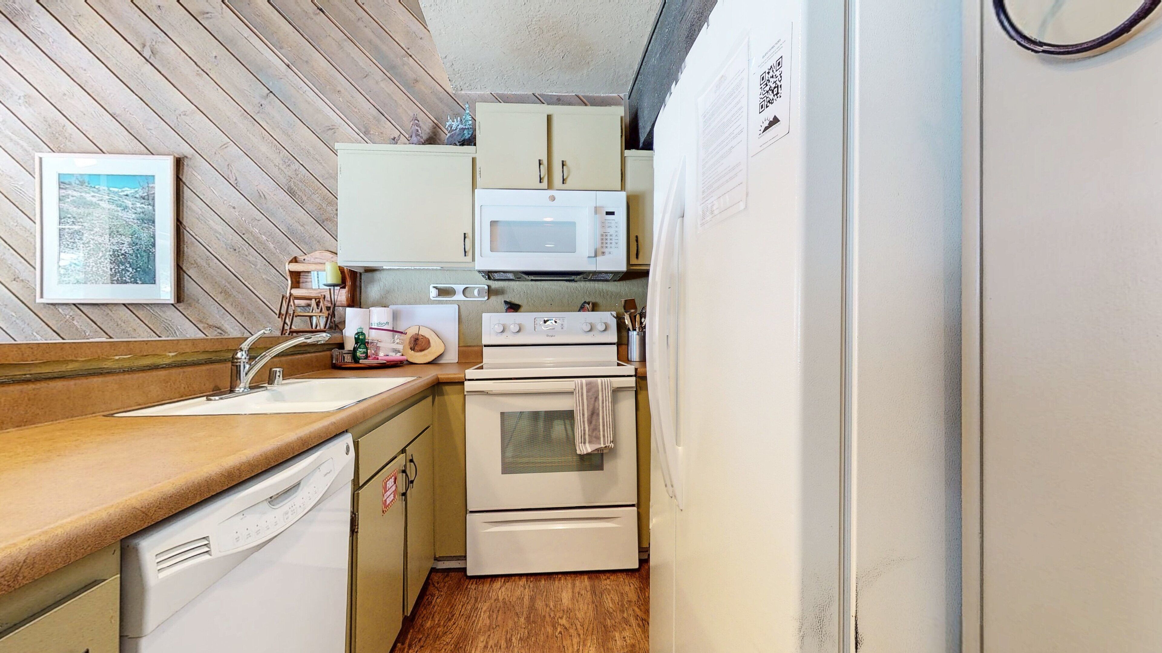 A compact kitchen with a sink, microwave, stove, and oven.