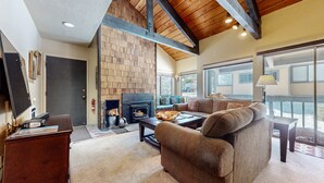 A cozy living room with a fireplace, a sofa, and a coffee table. - Bigwood 62 Quiet and Cozy in Forest Setting, with Garage Parking by RedAwning (Mammoth Lakes)