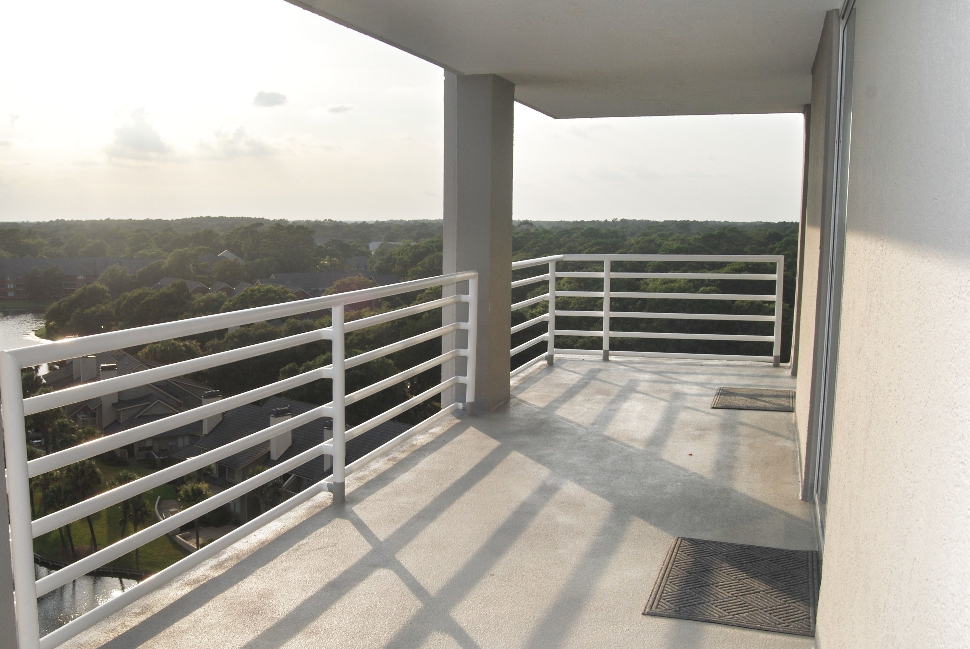 Un balcón con vistas a una zona residencial y un cuerpo de agua.