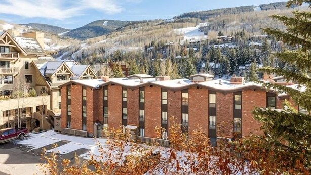 A hotel with a modern brick facade, multiple windows, and a parking lot. - Condos with Ski Locker and Vail Mountain Views by RedAwning (Vail)