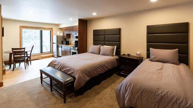A modern bedroom with two beds, a desk, and a chair. - Spacious Condo with Outdoor Heated Pool and Hot Tubs by RedAwning (Vail)