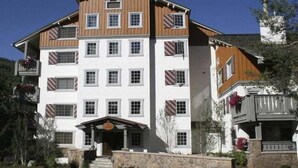 Un hotel de diverses plantes amb una façana simètrica, grans finestres i fonaments de pedra.