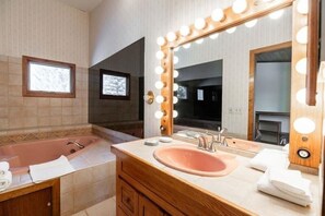 Bathroom features a standalone bathtub, sink with a basin, and ample lighting.