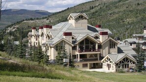 A large resort with multiple buildings, including a main lodge with a balcony and a smaller annex.