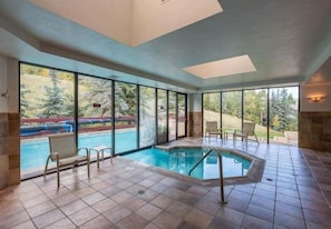 A swimming pool with a view of a forest and a clear sky.