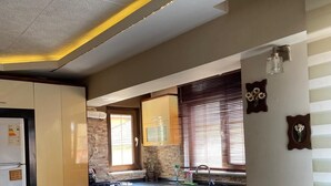 Una cocina moderna con una isla grande, electrodomésticos integrados y un comedor con sillas.